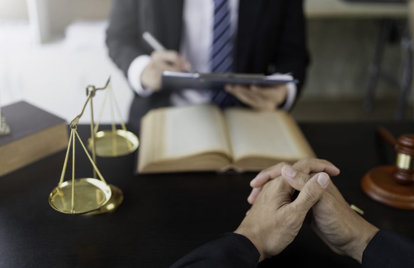 Attorney or judge provides legal advice to clients in the courtroom including the impartiality of the contract terms.